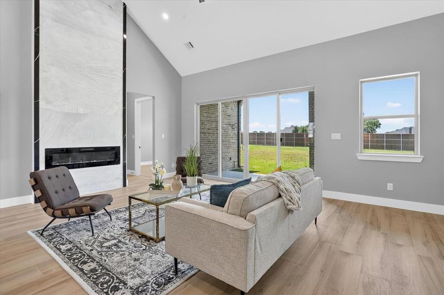 Spacious living area featuring a vaulted ceiling and light wood-finish flooring