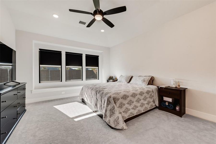 Bedroom featuring light colored carpet, ceiling fan, and recessed lighting