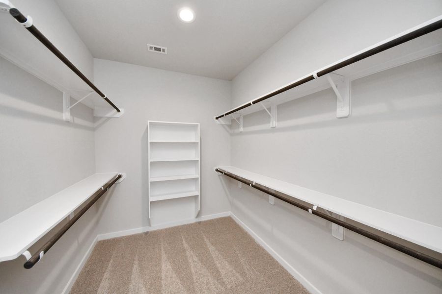 Walk-in closet that epitomizes luxury and practicality. This generously sized space features built-in shelving, offering abundant room for impeccable organization. High ceilings and recessed lighting create a bright and welcoming ambiance. Sample photo of completed home with similar floor plan. Actual colors and selections may vary. Walk-in closet that epitomizes luxury and practicality. This generously sized space features built-in shelving, offering abundant room for impeccable organization. High ceilings and recessed lighting create a bright and welcoming ambiance. Sample photo of completed home with similar floor plan. Actual colors and selections may vary.