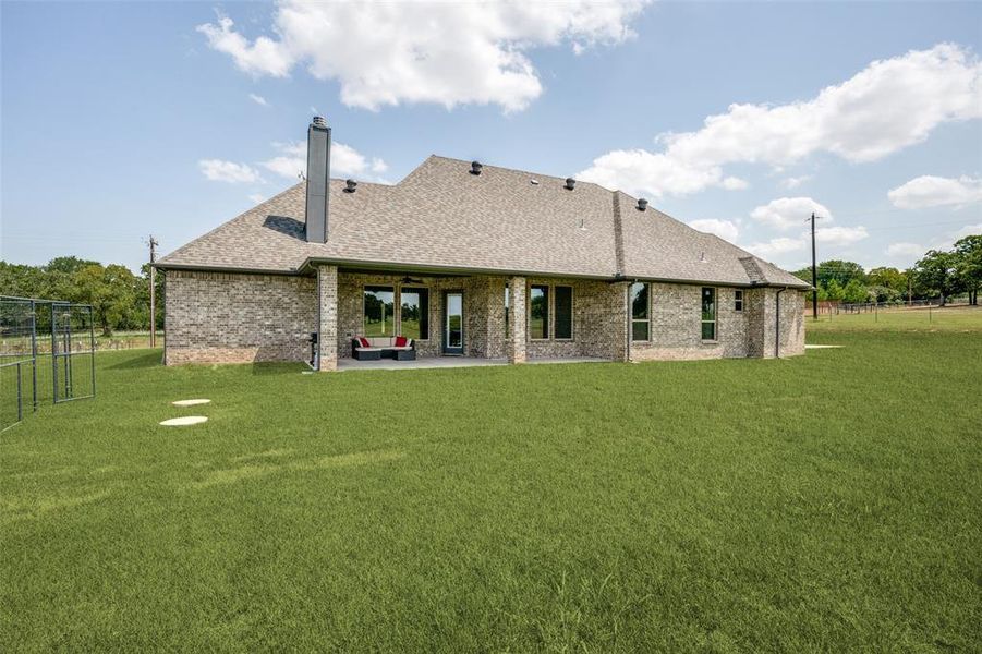 Rear view of property with a patio area and a lawn