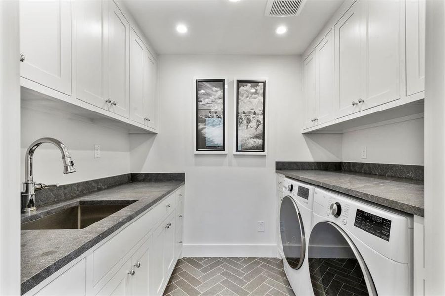 Laundry room with tile flooring, sink, washing machine and clothes dryer, and cabinets