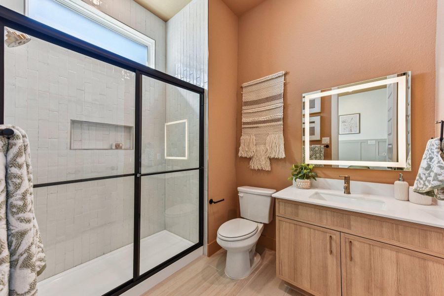 High ceilings and a glass-enclosed shower highlight this modern bathroom space.