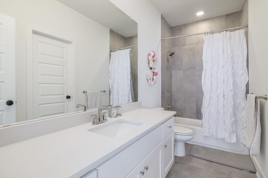 Another full bath showcases modern finishes and a cohesive design aesthetic.