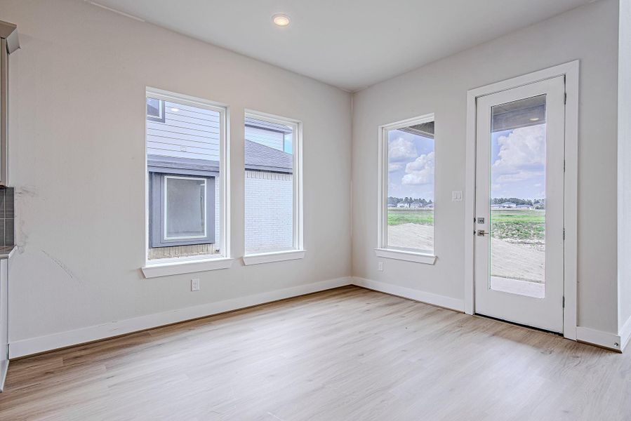 Enjoy dining with a view—this breakfast area is wrapped in windows and offers direct patio access, blending indoor comfort with outdoor potential.