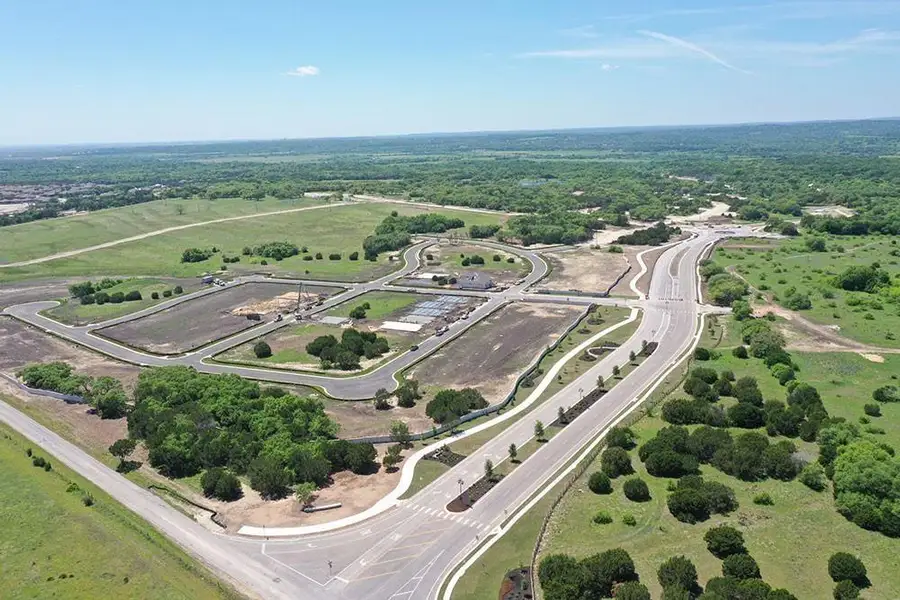 Aerial view of property and surrounding area with a heavily wooded area