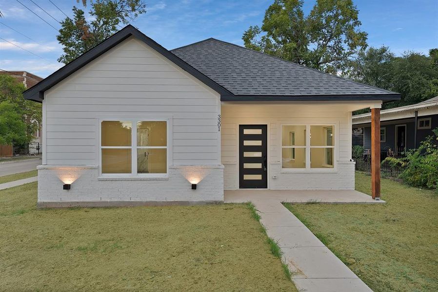 View of front of house featuring a shingled roof and covered porch