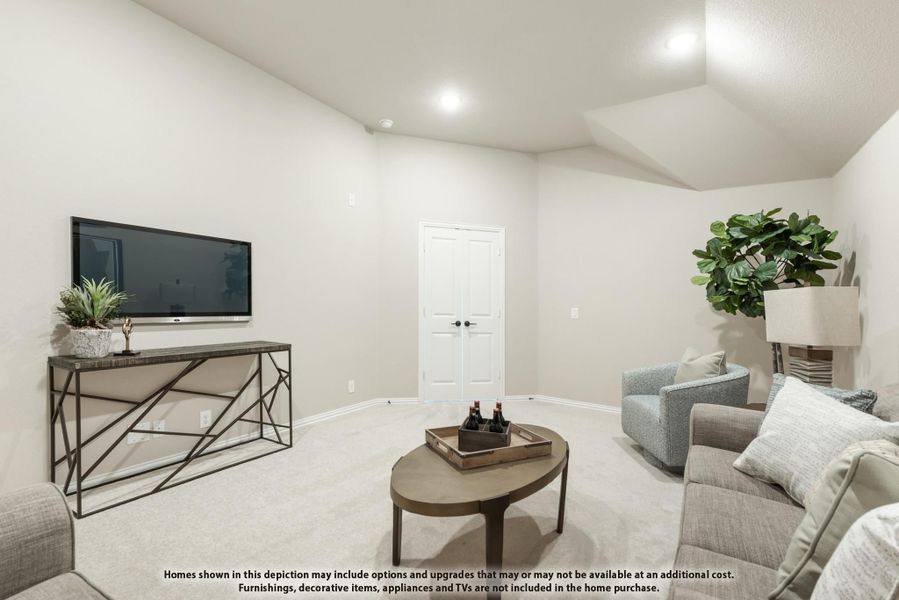 Living room with vaulted ceiling, wall-mounted TV, gray sofa, and carpeted floors Living room with vaulted ceiling, wall-mounted TV, gray sofa, and carpeted floors