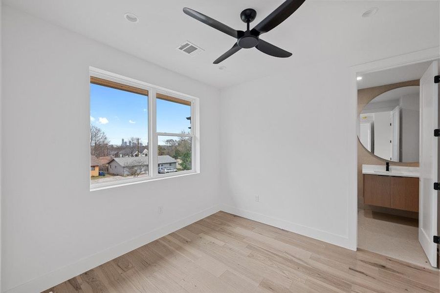 Unfurnished bedroom featuring light wood-type flooring, recessed lighting, ceiling fan, and ensuite bathroom