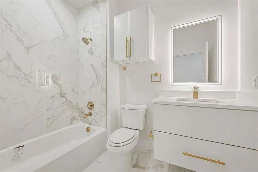Modern bathroom featuring a white bathtub with a tile surround, a sleek white vanity with a rectangular sink, an illuminated mirror, and gold-finish fixtures