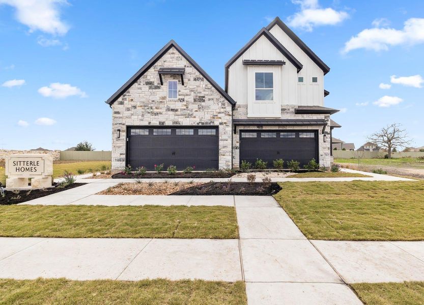 View of front of house featuring stone siding, board and batten siding, a front lawn, and an attached garage View of front of house featuring stone siding, board and batten siding, a front lawn, and an attached garage