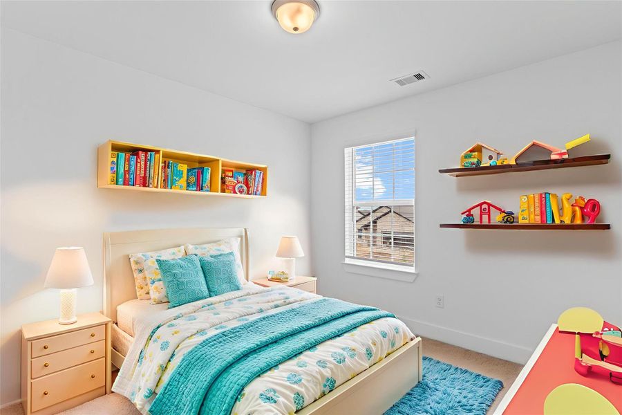 One of the spacious upstairs bedrooms offers soft carpet, neutral tones, and a large window that invites plenty of natural light—ideal for guests or family. *Virtually Staged* **Image Representative of Plan Only and May Vary as Built**.