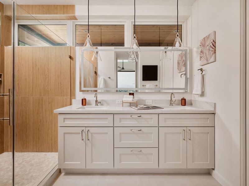 Double vanity featuring quartz countertops, undermount sinks, and white shaker-style cabinetry with chrome hardware