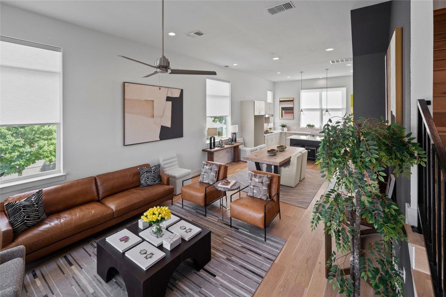Open-concept living area featuring light wood-finish flooring, recessed lighting, and a contemporary ceiling fan