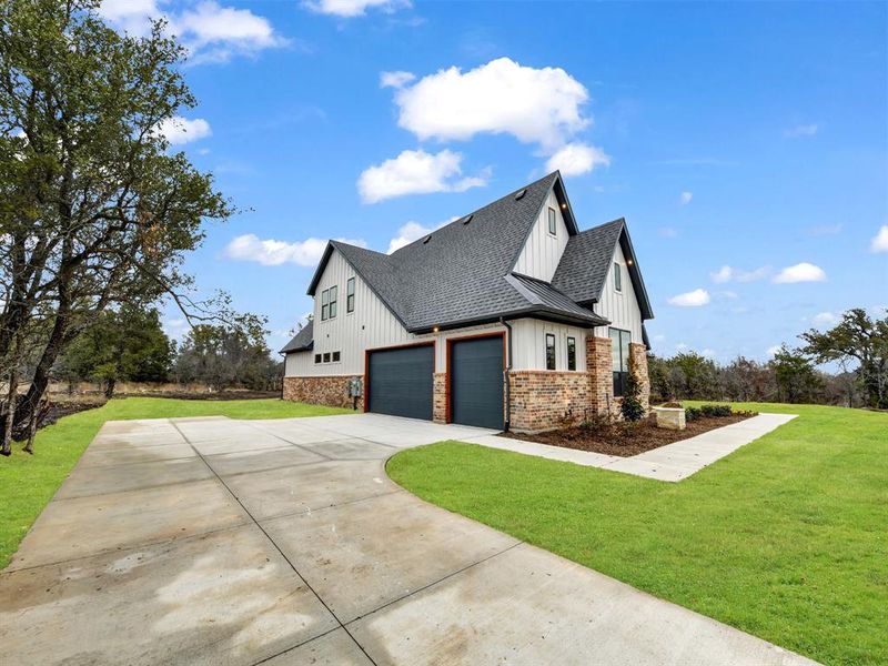 View of property exterior featuring a garage and a yard