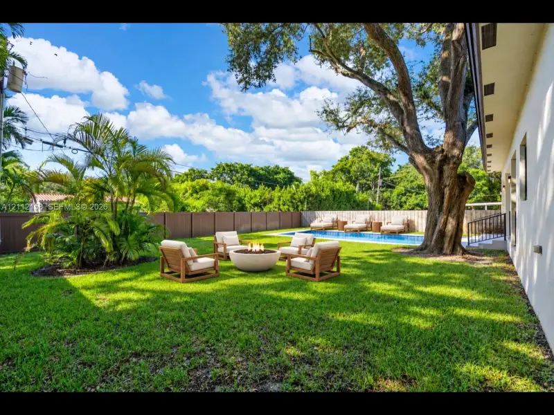 Enjoy evenings by the stone fire pit beside the pool, surrounded by mature trees and privacy fencing