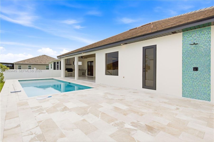 All overlooking sparkling custom pool surrounded by elegant marble decking All overlooking sparkling custom pool surrounded by elegant marble decking