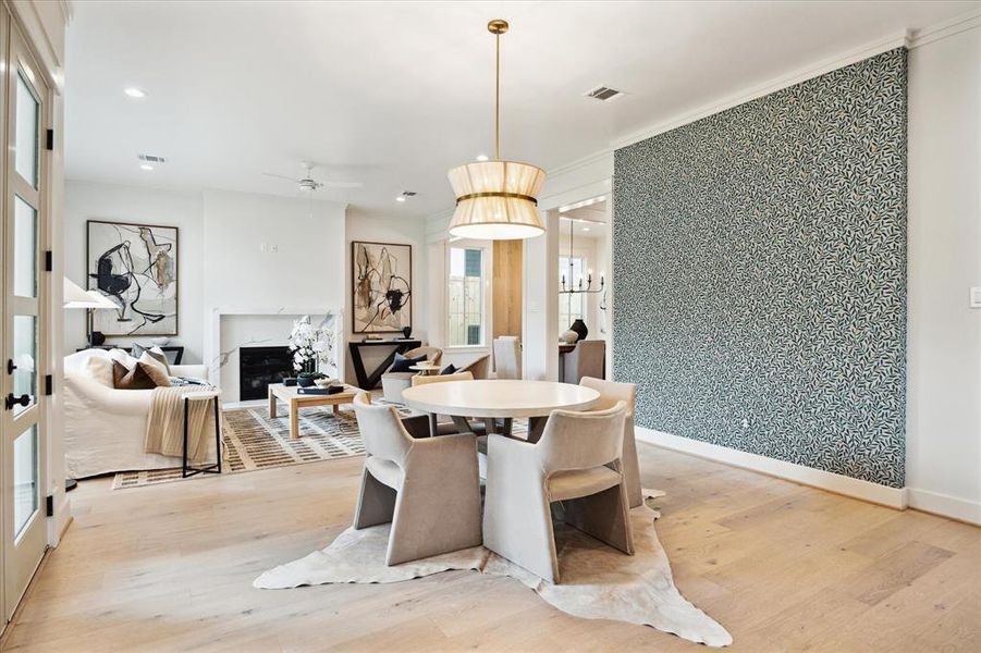 The breakfast area is anchored by a statement pendant light and one wall is adorned with the most spectacular wallpaper!