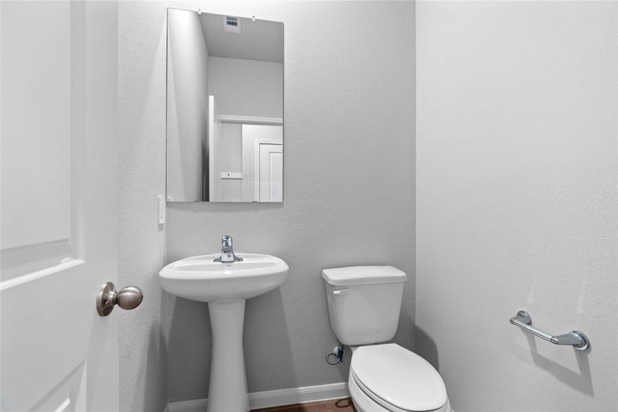 Conveniently located on the main level, this chic and functional powder room serves as a stylish 'jewel box' for guests. Featuring a clean and intentional design, it provides an essential half-bath solution that avoids navigating through the private areas of the home.