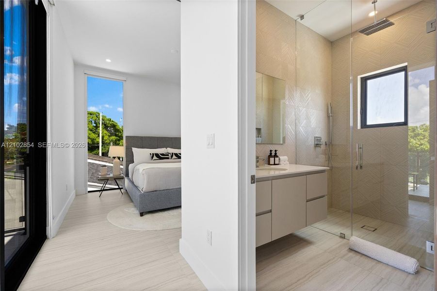 Wall-to-wall wood-finish flooring, glass-enclosed shower featuring textured wall tile and a rain showerhead, and a floating vanity with a stone countertop