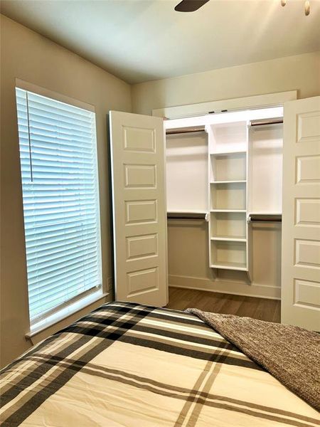 Unfurnished bedroom featuring dark wood-style floors, a closet, and multiple windows Unfurnished bedroom featuring dark wood-style floors, a closet, and multiple windows
