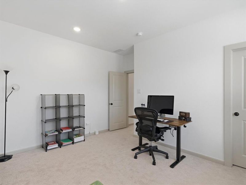 Neutral-toned carpeting and bright white walls provide a clean aesthetic