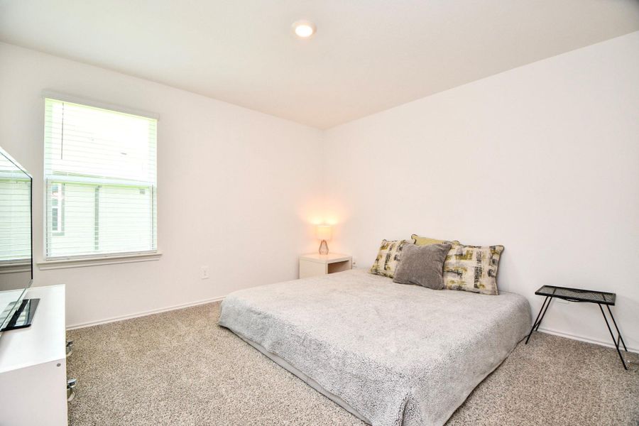 This bedroom is bright and minimalistic, with an en-suite bathroom attached to the right.