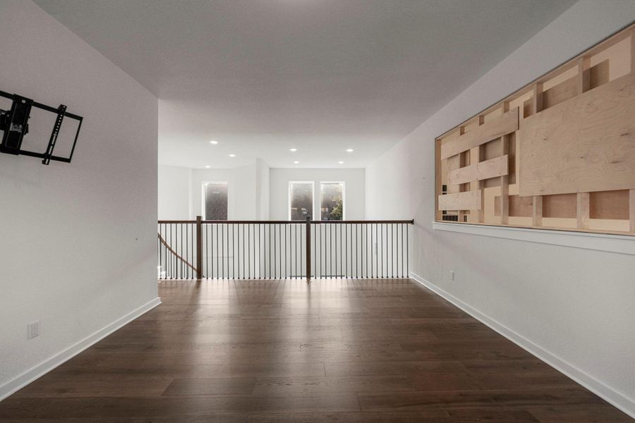A refined living area boasts rich hardwood floors and recessed lighting, offering an elegant setting.