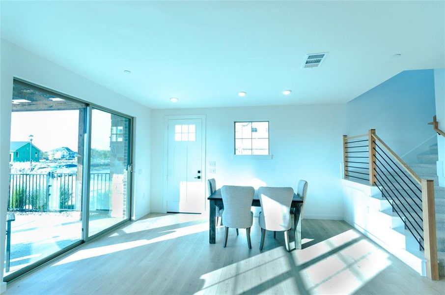 Dining room with light wood finished floors and stairway