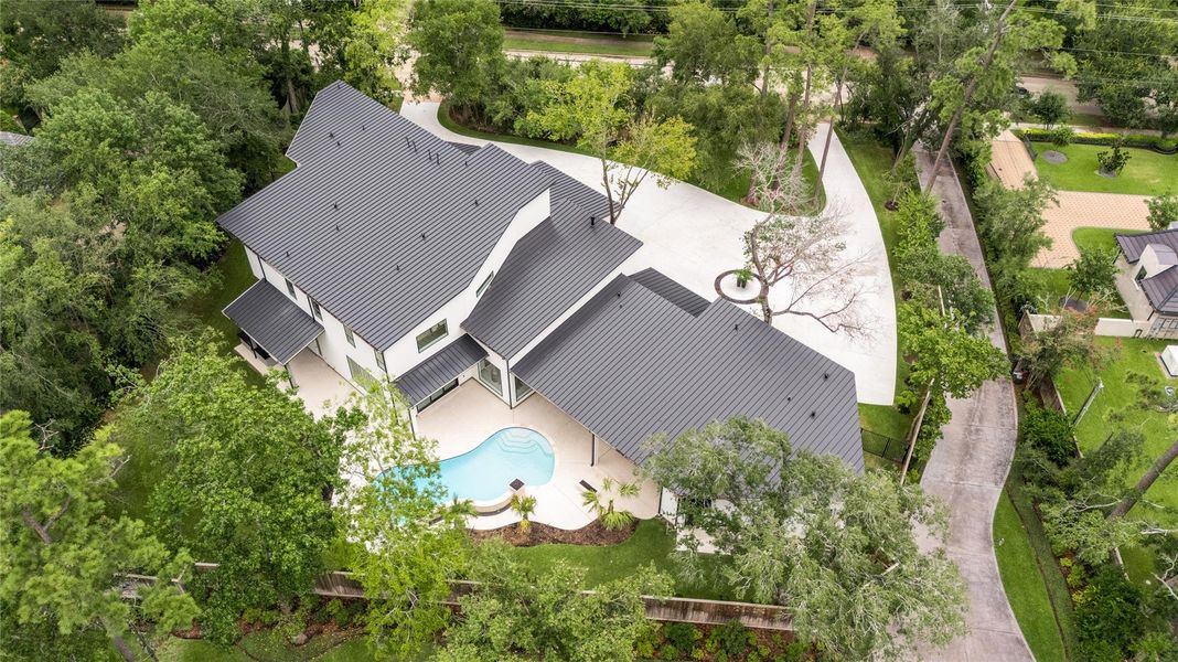 The contemporary design is crowned by an impressive standing seam metal roof, while mature trees envelop the lot, providing natural privacy. The contemporary design is crowned by an impressive standing seam metal roof, while mature trees envelop the lot, providing natural privacy.