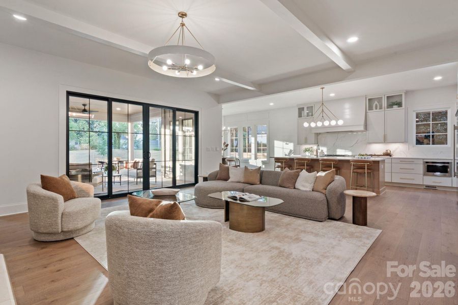 Living room opens to kitchen, dining area, and covered back patio