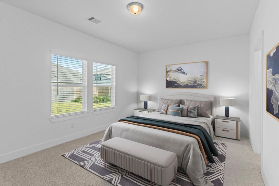 The peaceful primary bedroom is filled with natural light and soft carpet, creating a warm and relaxing retreat after a long day. *Virtually Stage Photo*