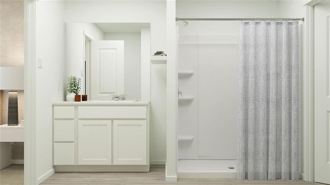 Full bath with wood finished floors, a shower stall, vanity, and baseboards