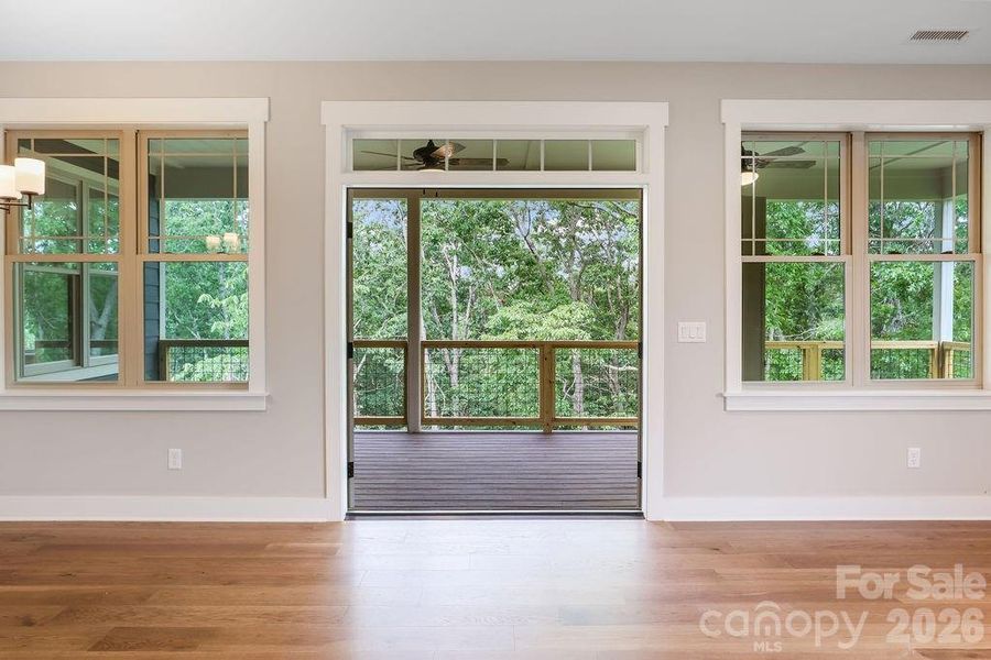 French doors open to large, covered Trex deck overlooking private wooded view.