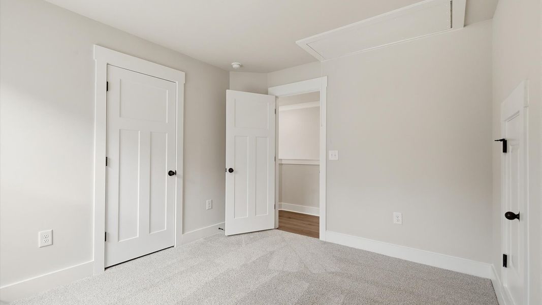 Elegant bedroom retreat featuring soft carpeting and a thoughtfully designed walk-in closet by DRB Homes Elegant bedroom retreat featuring soft carpeting and a thoughtfully designed walk-in closet by DRB Homes