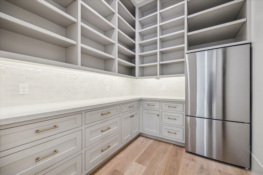 Kitchen pantry with ample amount of storage and an extra refrigerator. Kitchen pantry with ample amount of storage and an extra refrigerator.