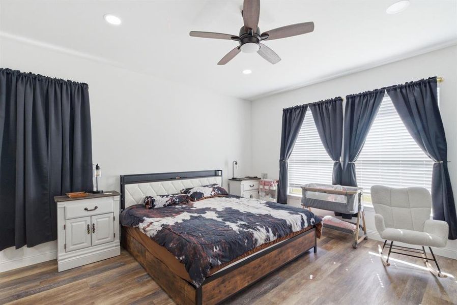 Bedroom featuring dark wood-type flooring, a ceiling fan, and recessed lighting Bedroom featuring dark wood-type flooring, a ceiling fan, and recessed lighting