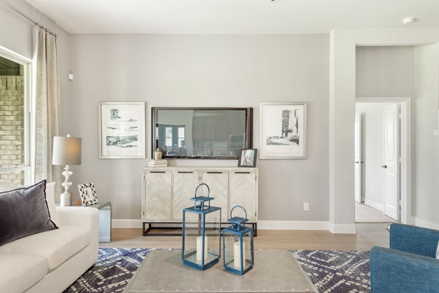 Living room with gray walls, white sofa, wall-mounted TV, and blue decorative lanterns on a coffee table