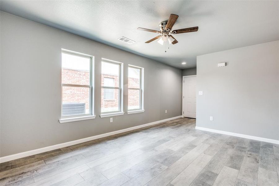 Unfurnished room with ceiling fan and light wood-type flooring