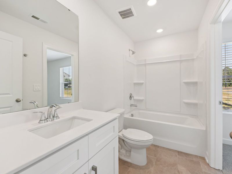 The secondary bathroom features a storage vanity and oversized shower tub. The secondary bathroom features a storage vanity and oversized shower tub.