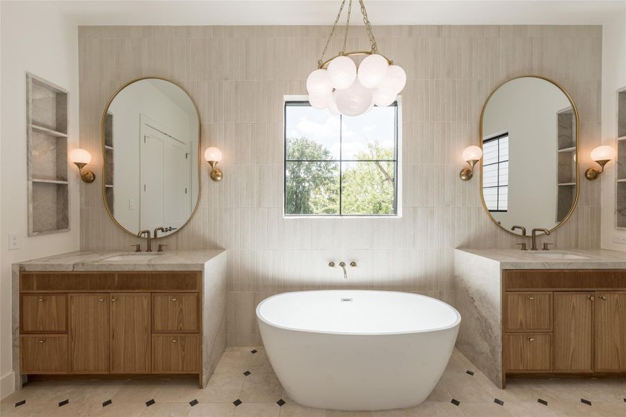 The spa inspired primary bath centers on a freestanding soaking tub, framed by natural stone, designer tile and sculptural lighting for a quietly dramatic focal point. The spa inspired primary bath centers on a freestanding soaking tub, framed by natural stone, designer tile and sculptural lighting for a quietly dramatic focal point.