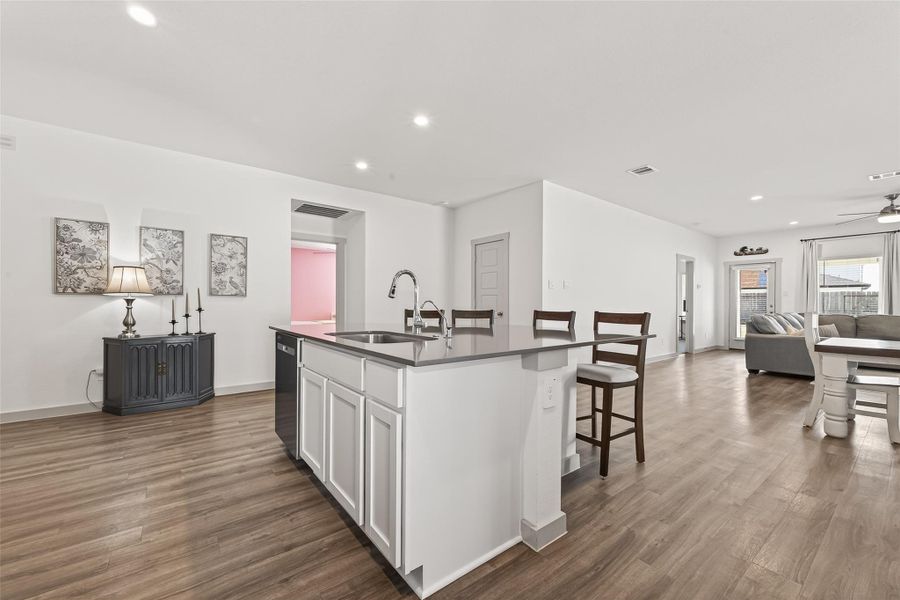 Kitchen island includes large single sink, water spout for filtration system option, kitchen open to living room, additional secondary bedroom to the left, storage closet straight ahead, entry to primary bedroom to the right. Kitchen island includes large single sink, water spout for filtration system option, kitchen open to living room, additional secondary bedroom to the left, storage closet straight ahead, entry to primary bedroom to the right.