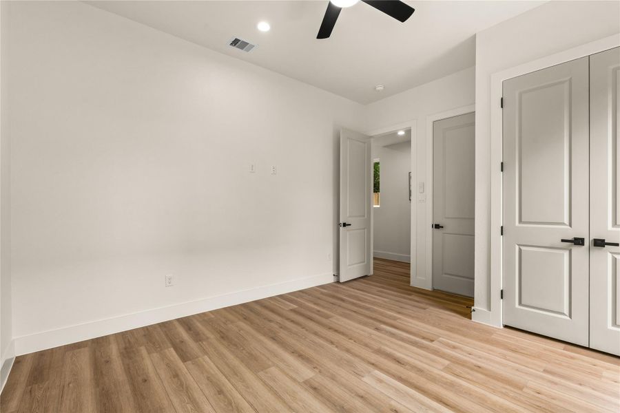 Main-level bedroom with ceiling fan, closet, and its own full bath steps away Main-level bedroom with ceiling fan, closet, and its own full bath steps away