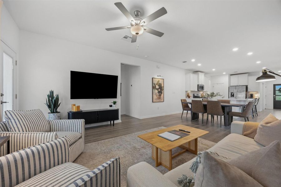 Open-concept living space featuring wood-finish flooring, recessed lighting, and a ceiling fan
