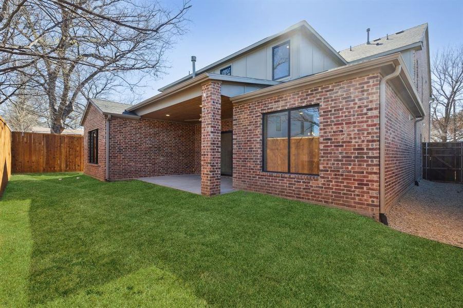 Back of property featuring yard space and a patio