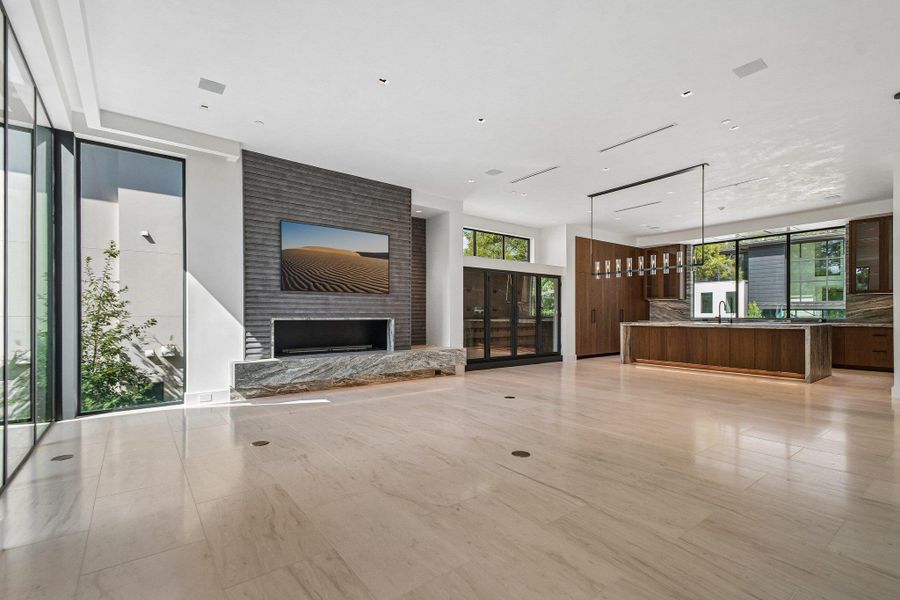 Polished tile flooring and a massive stone-clad fireplace anchor this open-concept living space. Polished tile flooring and a massive stone-clad fireplace anchor this open-concept living space.