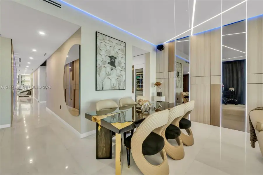 Large-format tile flooring, wood-finish paneled walls with integrated linear LED accent lighting, recessed ceiling lighting, and built-in climate-controlled wine storage Large-format tile flooring, wood-finish paneled walls with integrated linear LED accent lighting, recessed ceiling lighting, and built-in climate-controlled wine storage