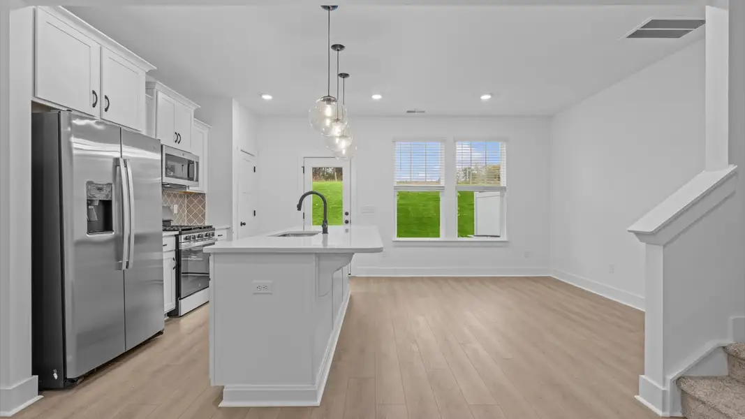 Top-notch kitchen featuring pendant lighting over a statement 9-foot island with seating Top-notch kitchen featuring pendant lighting over a statement 9-foot island with seating