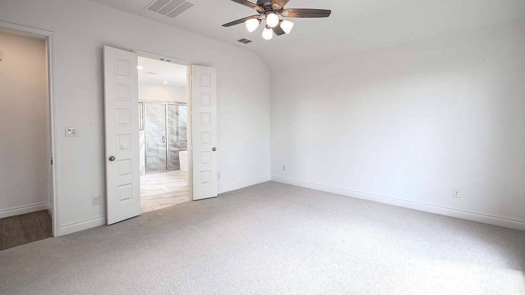 Unfurnished bedroom featuring ceiling fan, ensuite bath, and light colored carpet Unfurnished bedroom featuring ceiling fan, ensuite bath, and light colored carpet