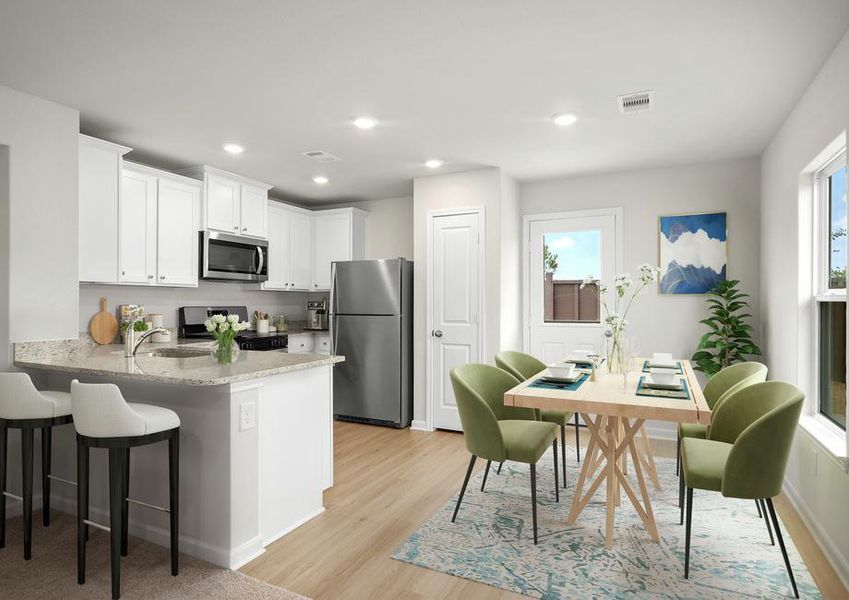 The staged kitchen has beautiful stainless steel appliances and plank flooring.