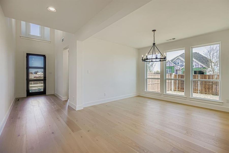 Unfurnished dining area featuring a chandelier, light wood-type flooring, and recessed lighting Unfurnished dining area featuring a chandelier, light wood-type flooring, and recessed lighting